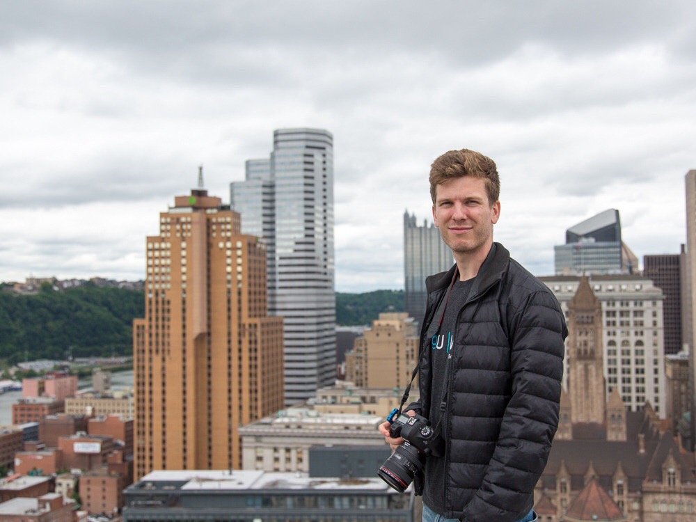 An image of a man on a rooftop, overlooking Pittsburgh